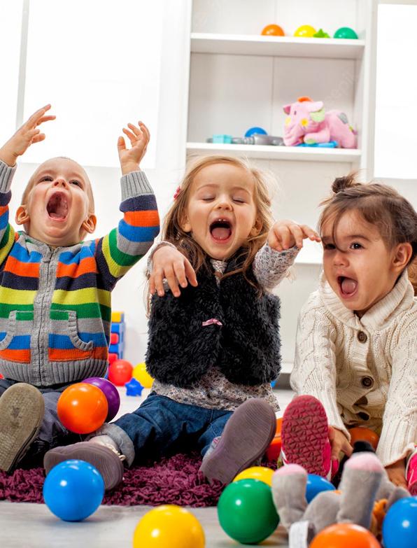 Three young children playing with plastic balls